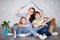 A mother with her son and daughter moves into a new apartment with things in cardboard boxes. The family creates a roof