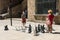 A mother and her son play with a giant chess in the square of the old medieval hospital, in the Raval neighborhood, in Barcelona.