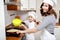 Mother and her son in white chef hats preparing an omelet in the kitchen.