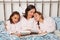 Mother with her two daughters at bedtime reading a book