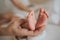 Mother hold feets of newborn baby.Skin care concept