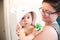 Mother holding baby with bathrobe after eavning bath