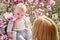 Mother holding baby in the blooming magnolias garden