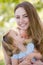 Mother holding daughter outdoors smiling