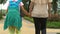 Mother holding son by hand, walking to school for first time, encouraging kid