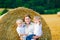 Mother holding two children on arms on wheat field in summer