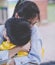 Mother holding an upset boy closely in her arm, for mother and parent caring concept