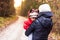 Mother holds baby girl in arms in moody forest