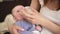 Mother holds four months old baby infant boy on her hands, feeding him milk from bottle