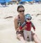 A mother holds her baby in the gentle ocean surf