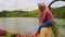 Mother Holds Little Girl on Shoulders Walks on Bank by Lake