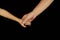 Mother holds son for hand. Isolated women and children palms on a black background. The concept of family relations, love, kindnes