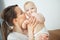 Mother hugs baby toddler smelling his tasty body, happy moments