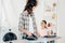 mother ironing and looking to daughter standing near