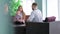 Mother keeping on her knees little son sitting in chair talking with doctor