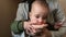 Mother keeps child in his arms and fed a slice of apple.