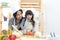 Mother and kid girl cooking and cutting vegetables