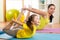 Mother and kid in the gym centre doing stretching fitness exercise. Yoga