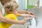 Mother and kid son washing their hands in the bathroom. Care and concern for children.