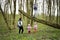 Mother with kids and boy climbed a felled tree in spring forest. Happy childhood moments