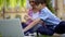 Mother with kids have lesson outdoors using laptop