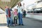 Mother with kids and luggage stands on platform