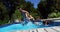 Mother and kids pulling father in swimming pool