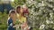 Mother with kids smelling blooming cherry tree