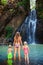 Mother with kids swim in water pool under waterfall