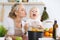 Mother kiss her child daughter while cooking pasta for the breakfast. Concept of happy family in the kitchen