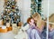 Mother kiss redhead little daughter near the Christmas tree at home