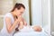 Mother kissing baby feet while play on a white window.