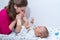 Mother kissing baby`s feet after changing a diaper to her little baby boy.