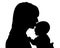 Mother kissing her newborn child silhouette