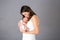 Mother kissing and hugging newborn son at gray background, tender, care, love