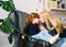 Mother kissing little redhead daughter with sitting in a armchair in a home interior
