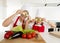 Mother and little daughter cooking together playing with cucumber slices on the eyes