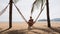 mother and little daughter roll in hammock across palm trees