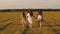 Mother and little daughter with sisters walking in park holding hands. Children and mom are playing in meadow. concept