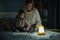 Mother and little daughter studying and drawing in a complete darkness during electricity outage. Little girl uses camping lantern