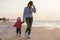 Mother and little daughter walking on the beach