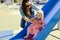 Mother and little daughter are walking and playing on the playground in the park