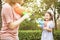 Mother and little girls playing water guns in the park