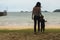 Mother and little her son is holding hand each other at the beach and looking beautiful sea