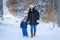 Mother with little son walking on snowy beach