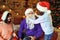 Mother looking at daughter putting Santa beard on father