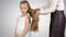 Mother makes daughter hairstyle on white background