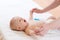 Mother or masseur massaging infant baby. Gymnastic, physical training, exercises for babies. Early development and