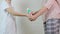 A mother measuring temperature of her son and showing normal temperature that on a display of infrared contactless thermometer,