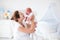 Mother and newborn baby in white nursery